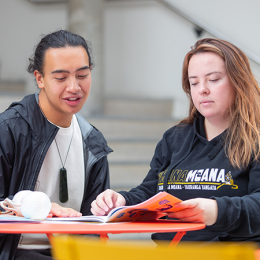 Two learners compare notes at the table