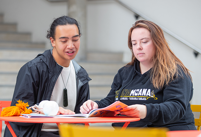 Two learners compare notes at the table