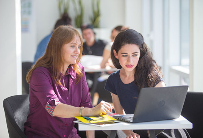 Two learners looking at the laptop