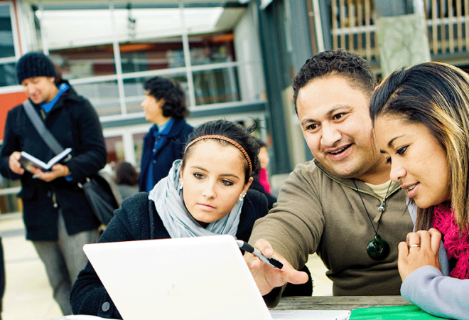 An educator instructing his learners with the aid of a laptop