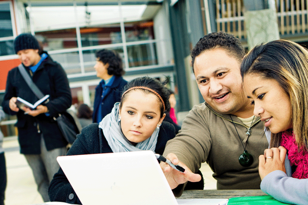 An educator instructing his learners with the aid of a laptop