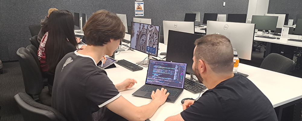 Dr Giacaman supervises a student writing code