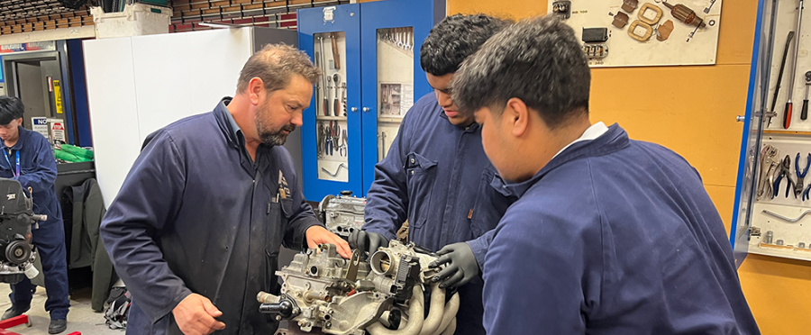 Richard guides two students through a practical activity